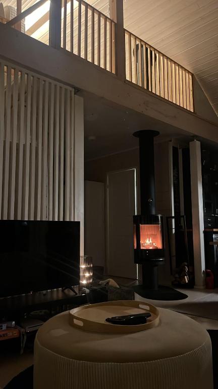 a living room with a tv and a round table at Villa Mustikkamaa in Lohja