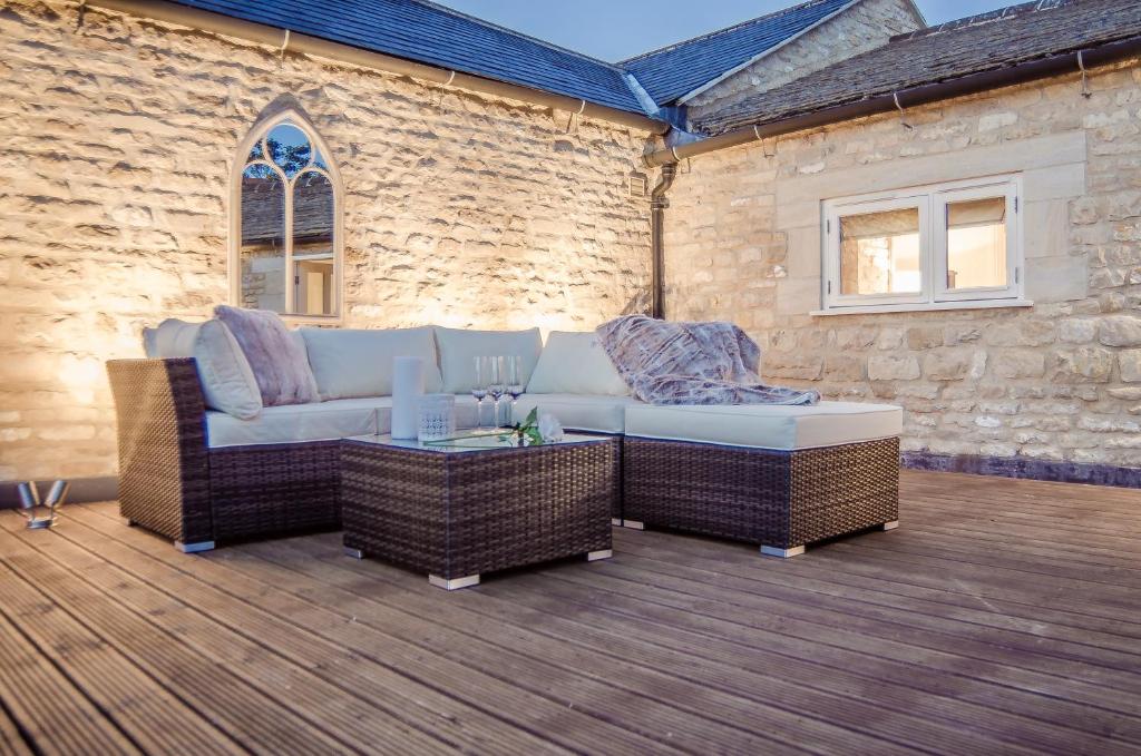 a patio with a couch and chairs and a table at Scotney Place in Stamford