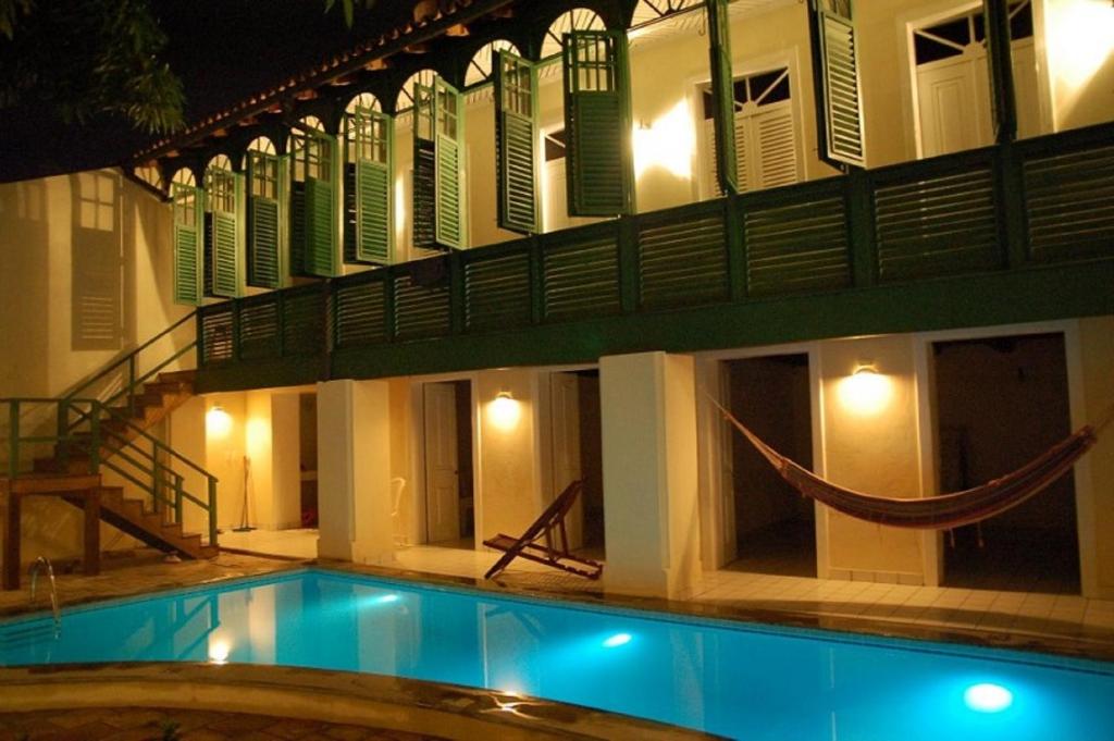 a swimming pool in front of a building at night at Casa Frankie in São Luís