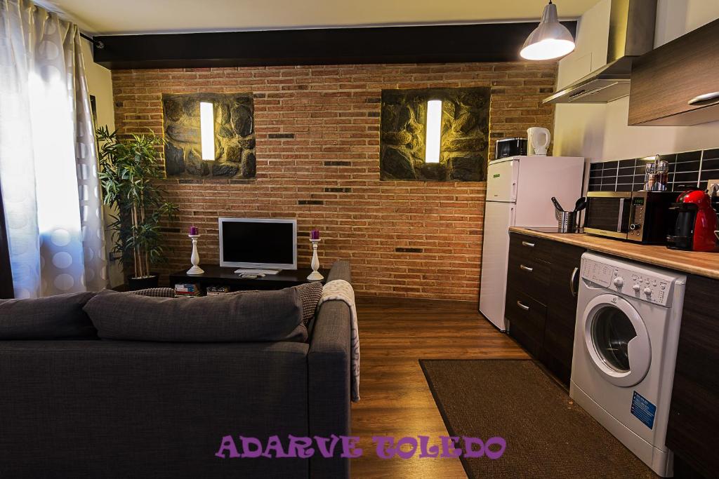 a living room with a couch and a kitchen at Apartamentos Adarve Toledo in Toledo