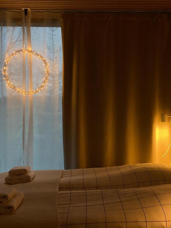 a bedroom with a bed and a window with a chandelier at RUSKA-mökki in Tyrnävä
