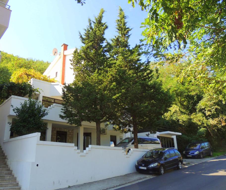 um carro estacionado em frente a uma casa com uma igreja em Villa Budvanka Guesthouse em Budva