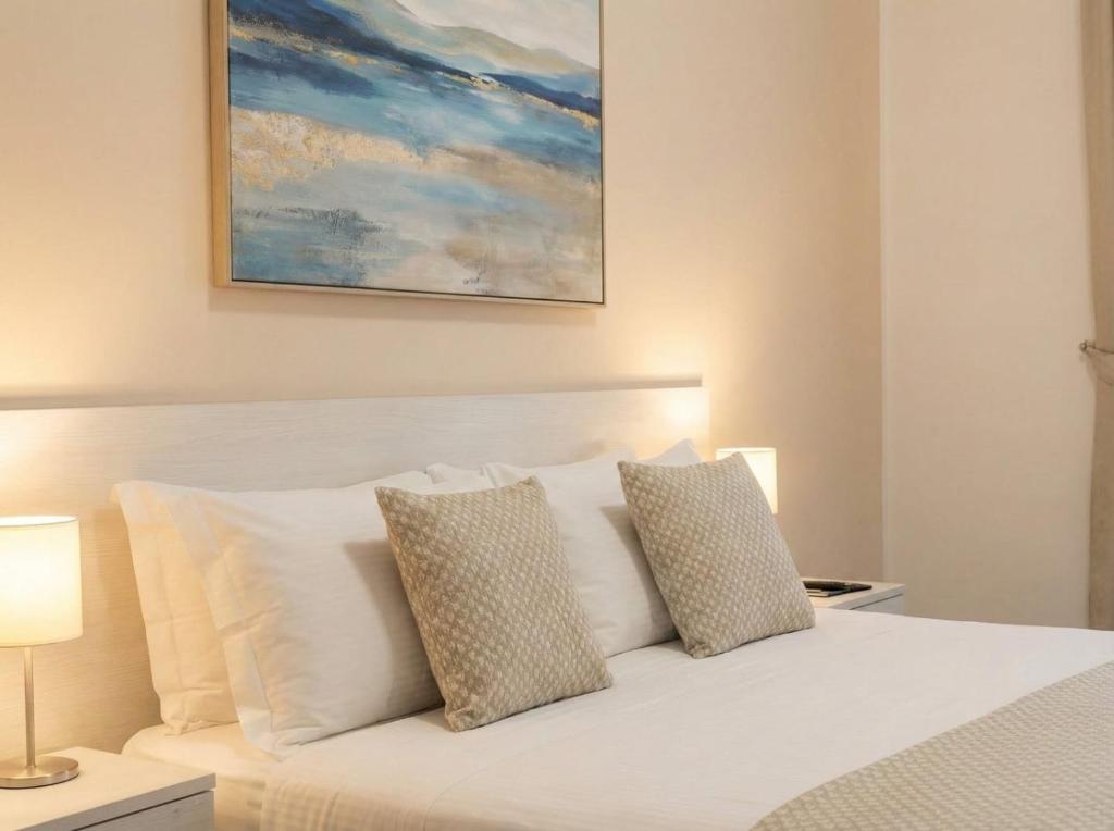 a bedroom with a white bed with two pillows at Orange City Center in Tirana