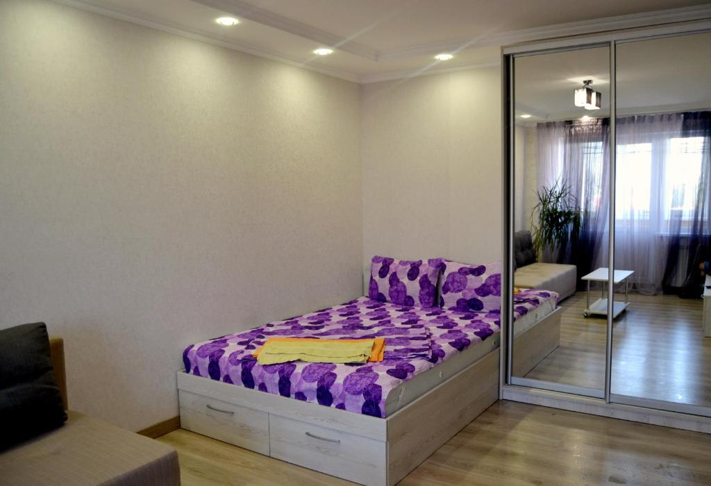 キーウにあるApartment on Bogdana Gavrilishyna 3のベッドルーム(紫色のベッド1台、鏡付)