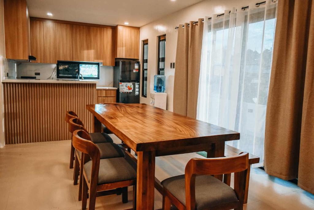 a kitchen with a wooden table and some chairs at Casa De Una Tagaytay in Galicias