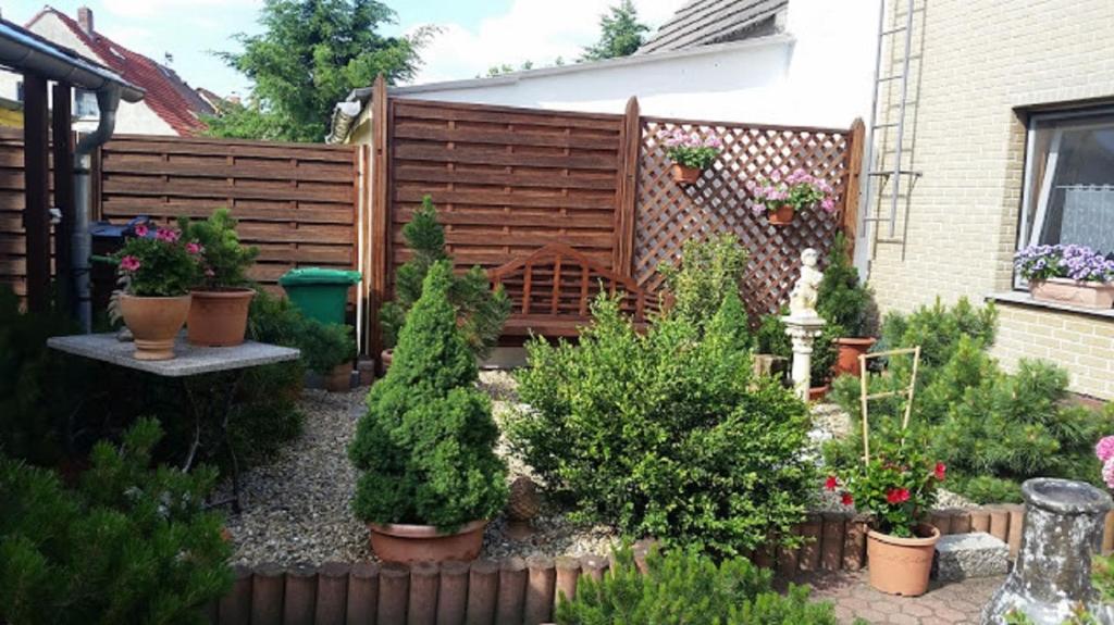ユーターボークにあるZimmervermietung M&R Bertuchの鉢植えの庭と木の柵