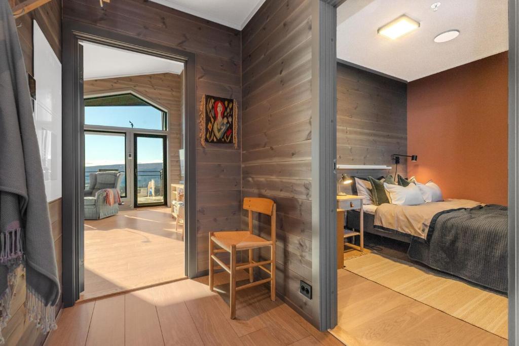 a room with a bed and a bedroom with a window at Riddertunets toppleilighet in Beitostøl