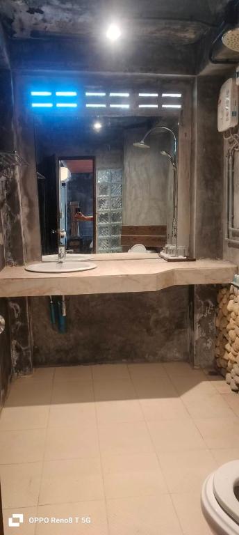 a bathroom with a sink and a large mirror at เวียงล้านนา รีสอร์ท in Ban Muang Pha