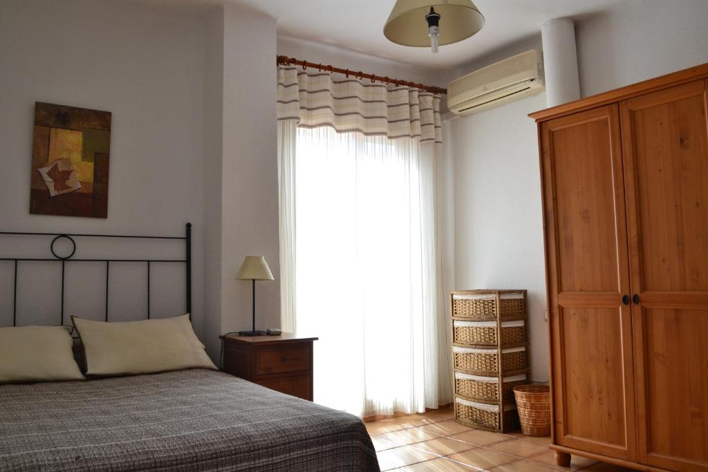 a bedroom with a bed and a large window at Can Llorach in Sant Jaume d'Enveja