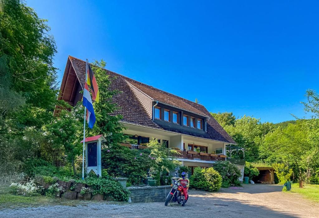a person on a motorcycle in front of a house at Gasthof Walhalja in Schmallenberg