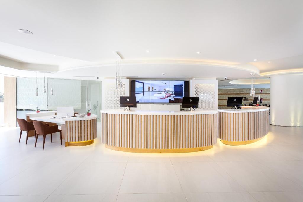a lobby with a table and a dining room at Tigotan Lovers & Friends Playa de las Americas - Adults Only (+18) in Playa de las Americas