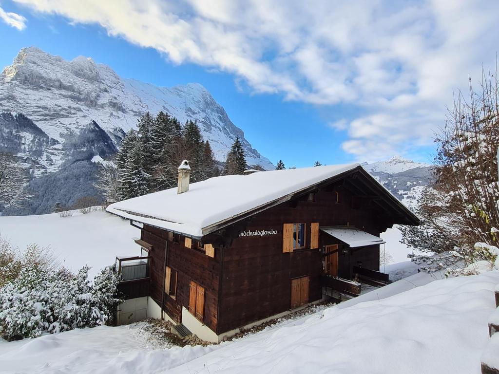 a cabin in the snow with mountains in the background at ABO - Boutique Apartment - Chalet Grindelwaldgletscher in Grindelwald