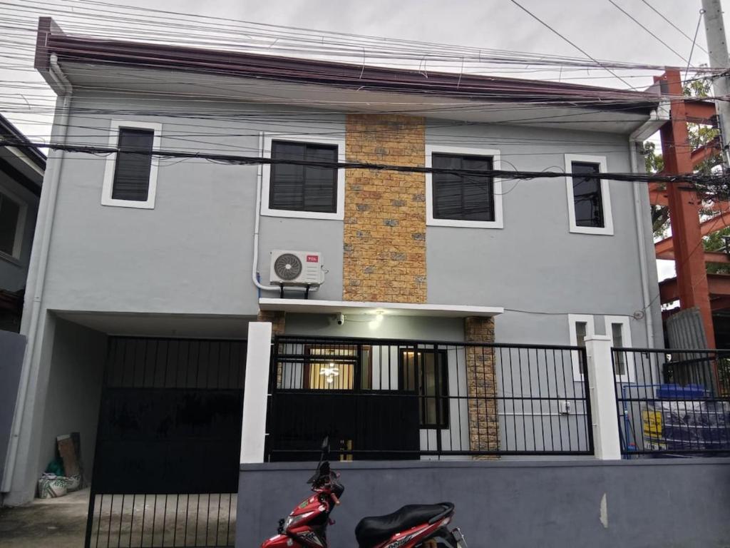 a house with a motorcycle parked in front of it at Welcome to Hambella home in Mactan
