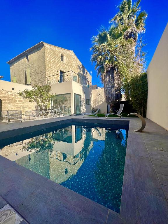 a swimming pool in front of a building at Cocon en petite Camargue in Aimargues