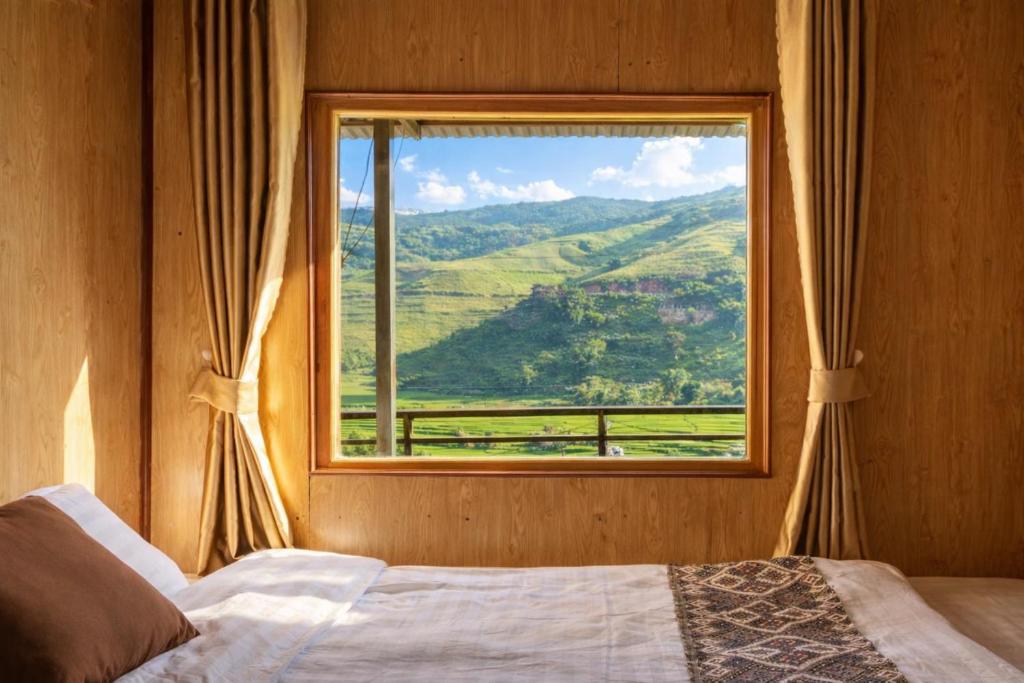 a bedroom with a window with a mountain view at PaoDzung Homestay Sapa in Sapa