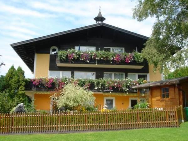 ein Haus mit einem Balkon mit Blumen darauf in der Unterkunft Ferienhaus Marianne in Abtenau