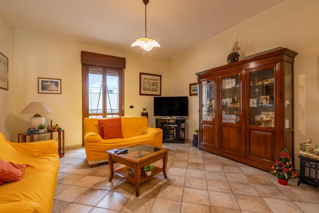 a living room with a yellow couch and a tv at ACQUARIO DEI FRALLE in Oristano