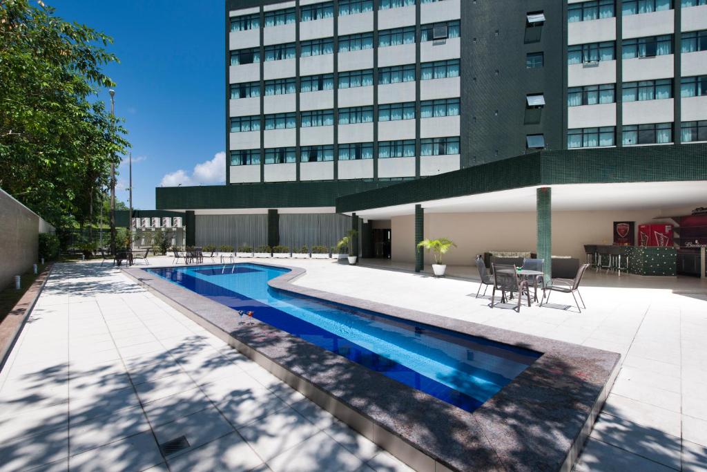 einem Pool vor einem Gebäude in der Unterkunft Comfort Hotel Manaus in Manaus