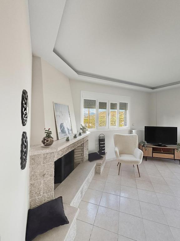 a living room with a fireplace and a chair at Spacious 3bd Apartment in Lefkakia, Nafplio in Levkákia