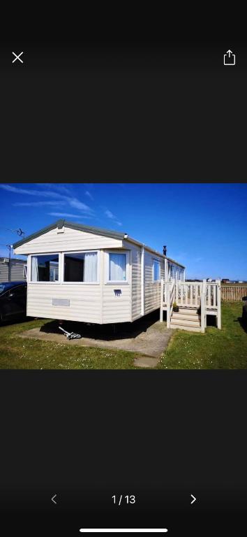 a white mobile home with a porch and a dock at 162 Northfield, 3 bedroom, 8 berth in Beeford