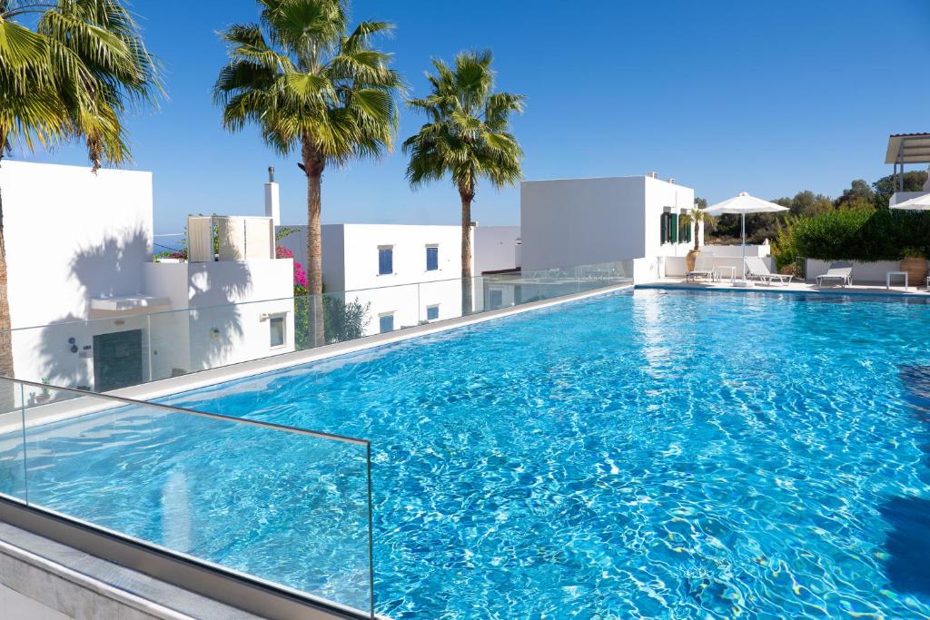 a large swimming pool on top of a building with palm trees at Outstanding Apartment in an Unique Aegean Inspired Settlement in Agia Triada