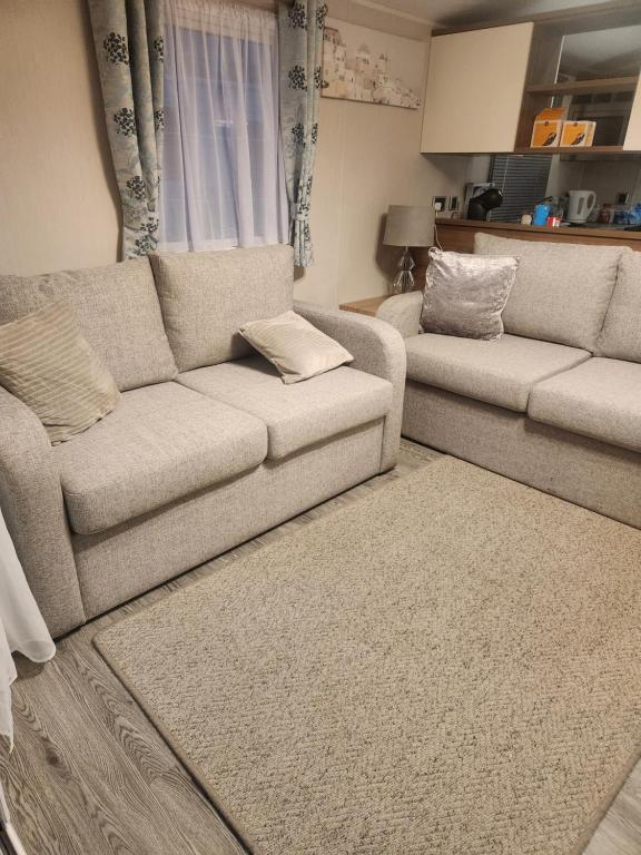 a living room with a couch and a rug at Sam's Caravan Hire Coastfield Holiday Village Ingoldmells in Ingoldmells