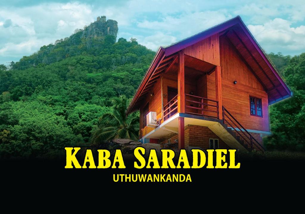 a small wooden building with a mountain in the background at Kaba Saradiel Cabin in Mawanella