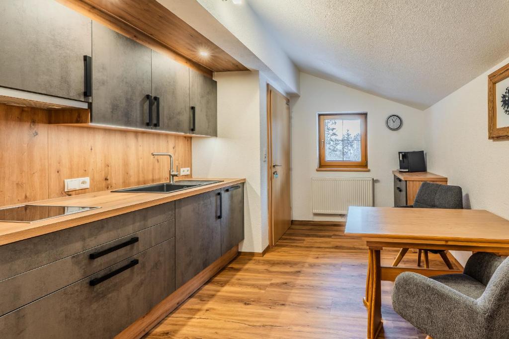 a kitchen with a sink and a wooden table at Appartements Kaltenbach in Kaltenbach