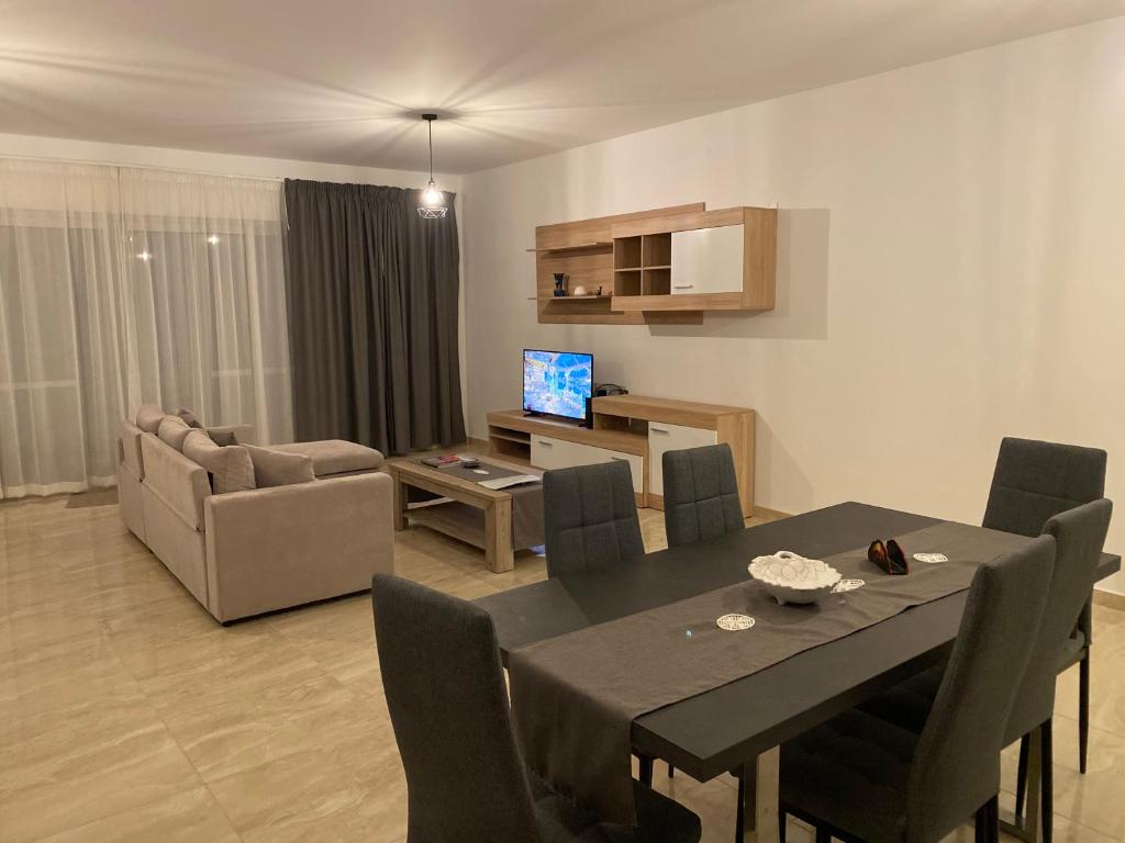 a living room with a table and a dining room at Xagħra Lodge in Xagħra