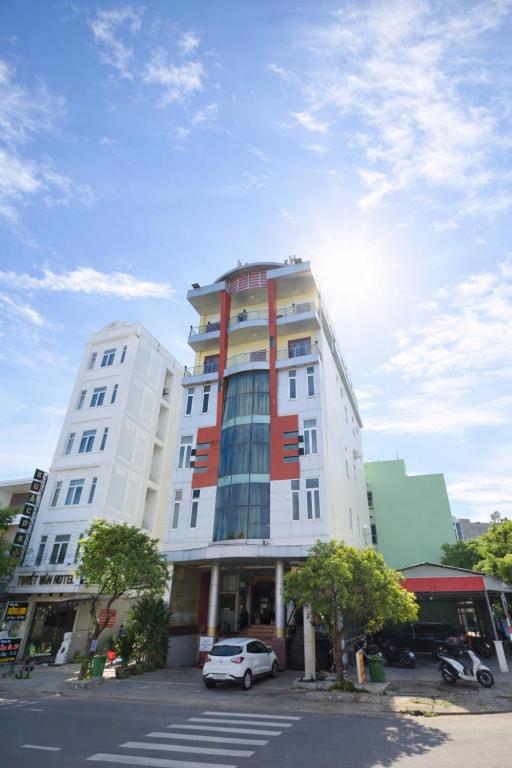 a tall white building with a car parked in front of it at Phương Anh 7- Only accept Vietnamese customers in Danang