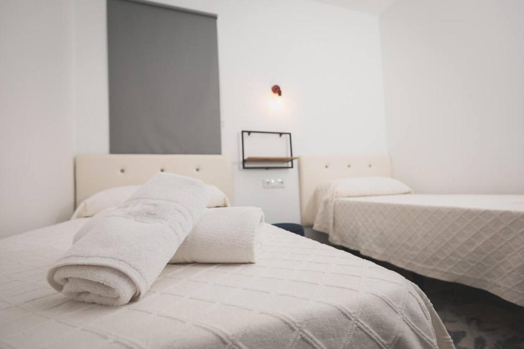 a room with two beds with towels on them at Hotel Rural Macondo in Trujillanos