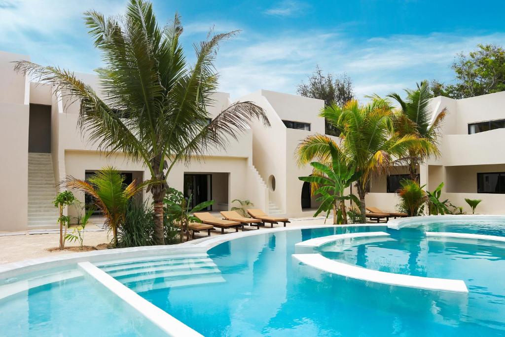a swimming pool in front of a villa at Kano Boutique Hotel Paje in Paje