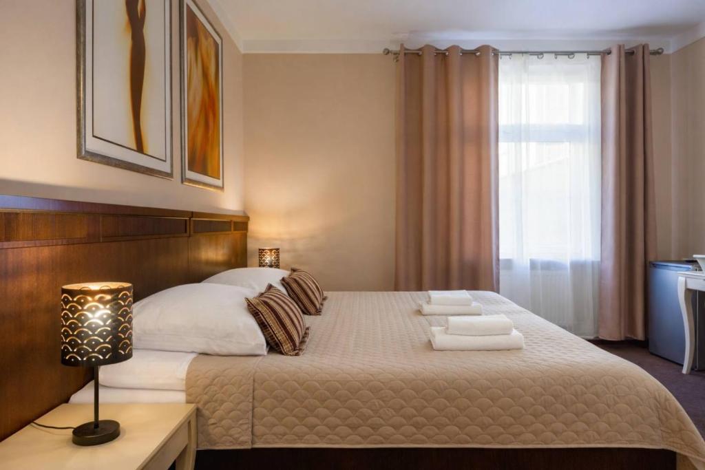 a bedroom with a large bed and a window at Royal Rooms Self Check-in in Poznań