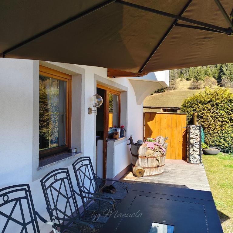 a patio with a table and chairs and an umbrella at Ferienwohnung Pusteblume4 in Oberau
