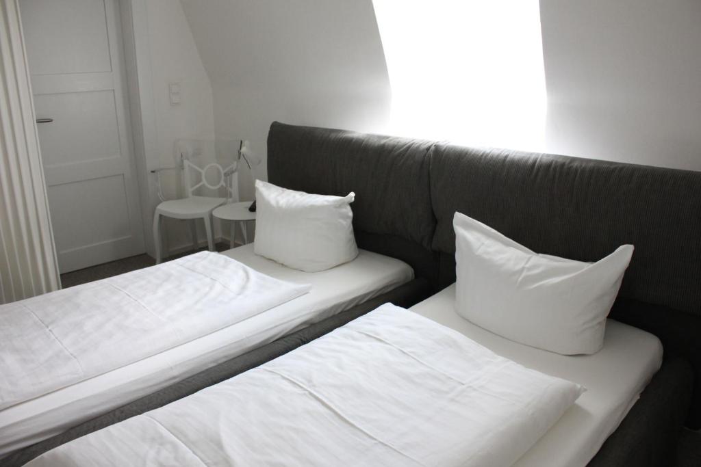 two beds with white sheets and pillows in a room at Tagungsvilla Weißer Berg in Neuwied
