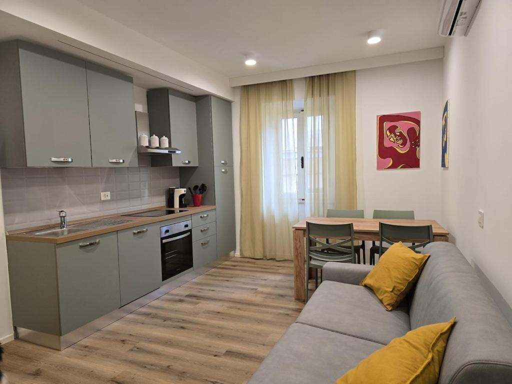 a kitchen and a living room with a couch and a table at Lovely Corner 2 in Porto Santo Stefano