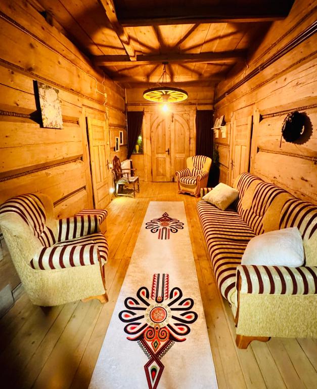 a living room with a couch and chairs in a cabin at Przytulisko Dom na wyłączność in Biały Dunajec