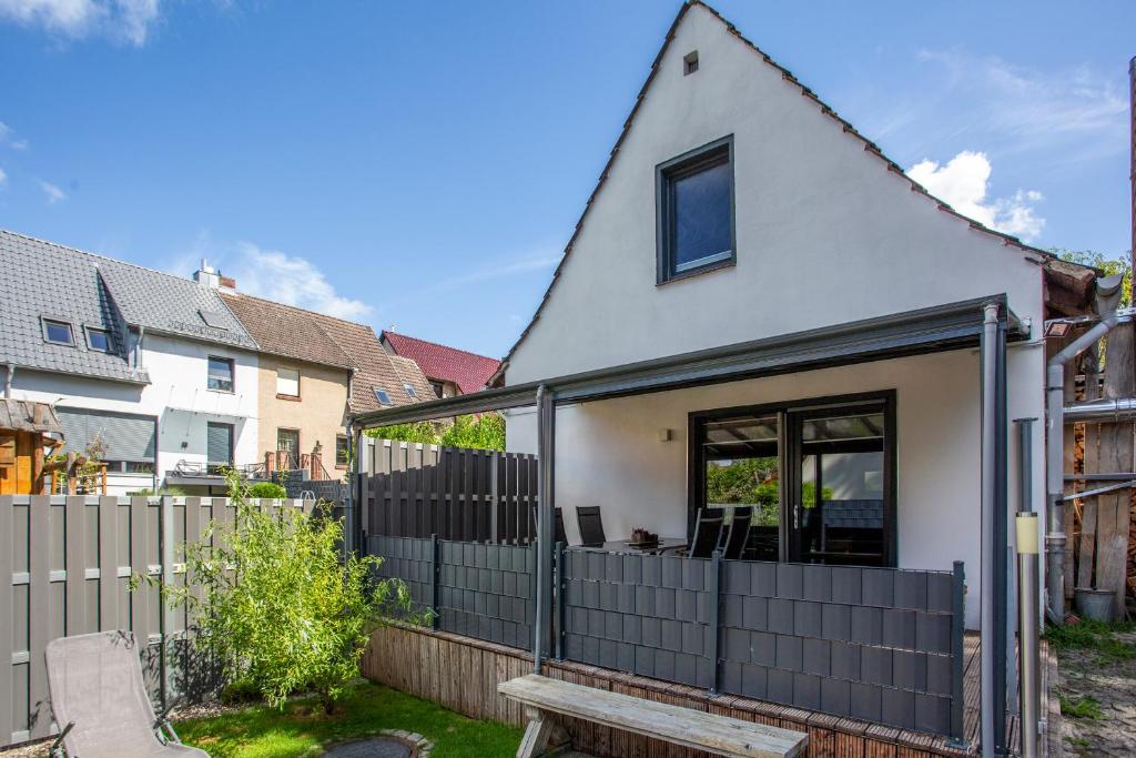 a white house with a fence and a bench at Ferienhaus Charlotta mit Terrasse in Waren