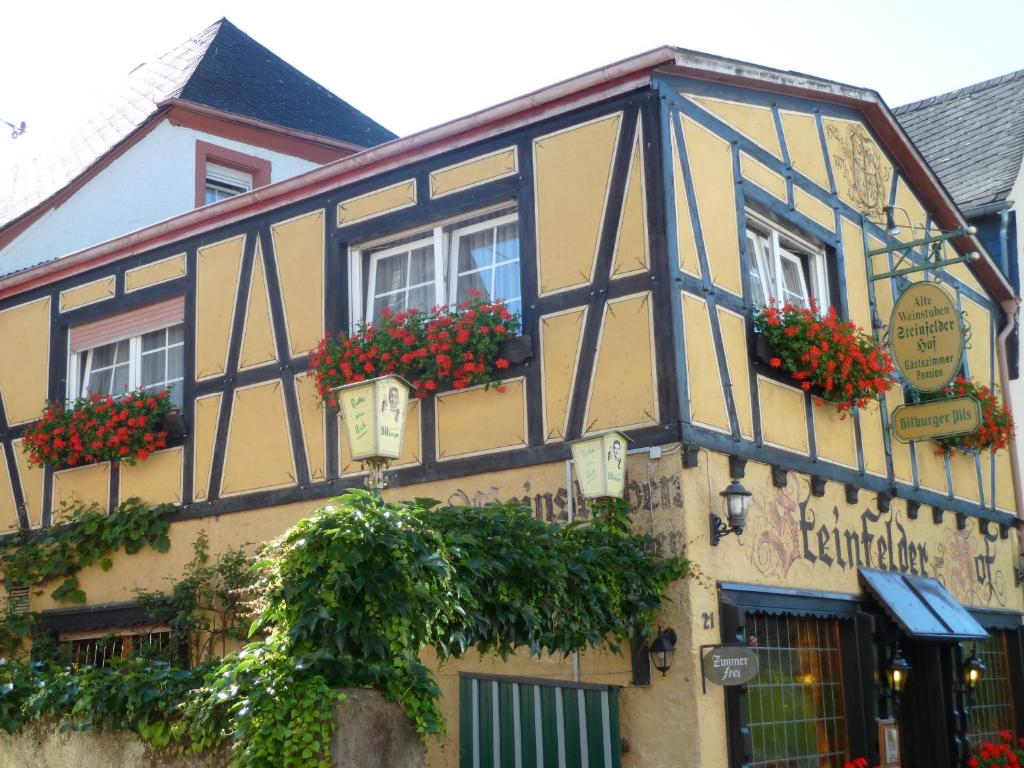 um edifício preto e amarelo com flores nas janelas em Alte Weinstuben Steinfelder Hof Garni em Ellenz-Poltersdorf