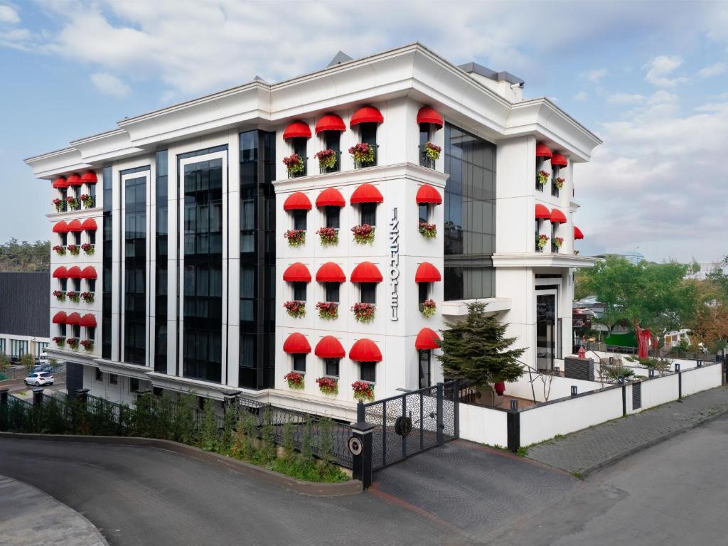 a white building with red balconies on a street at İzz Hotel Koşuyolu in Istanbul