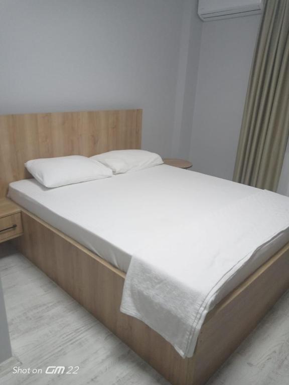a bed with white sheets and pillows in a room at Tekirdağ Begonya Hotel in Kapaklı
