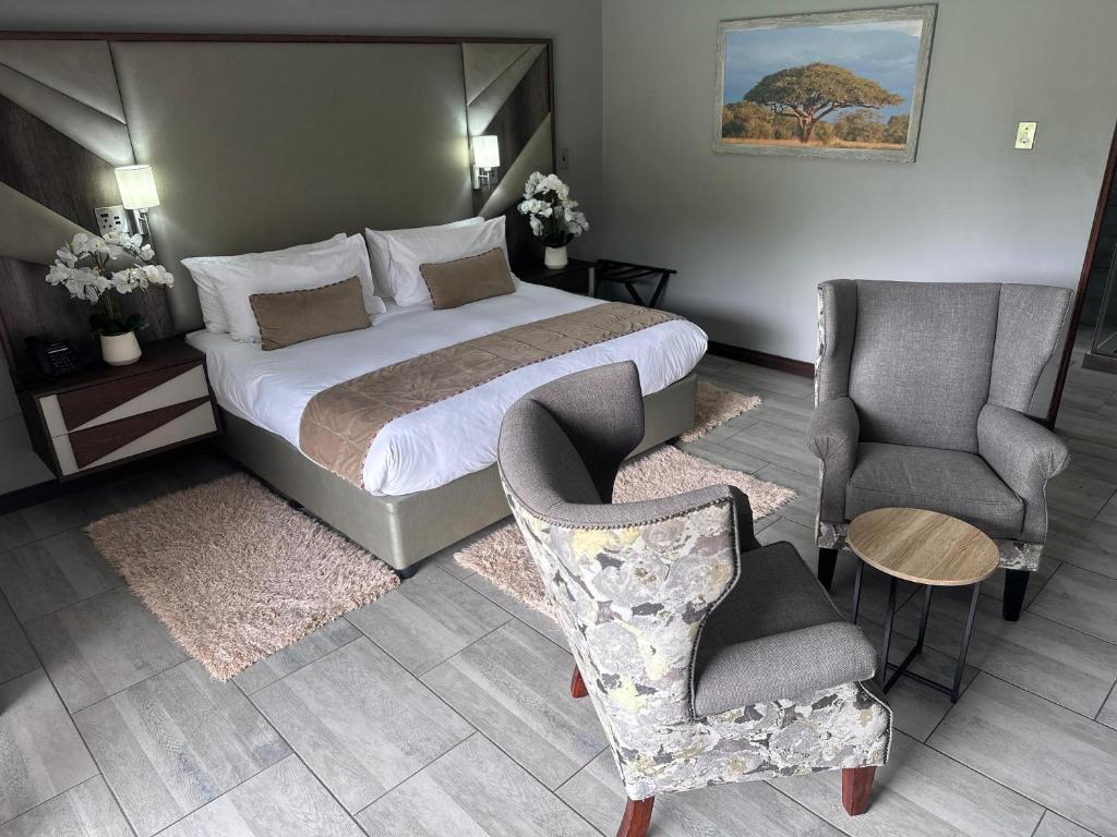 a hotel room with a bed and a chair at Vahlavi Lodge in Giyani