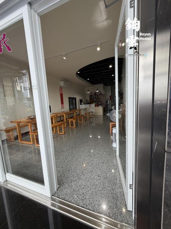 a window of a restaurant with tables and chairs at Boyun Hostel in Kaohsiung