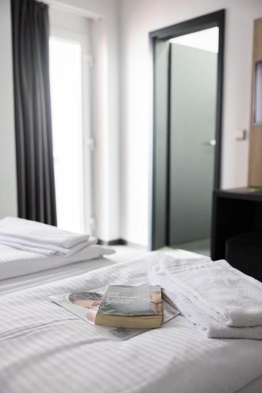 a book sitting on top of a bed with a mirror at N9 Hotel Nürnberg-City in Nuremberg