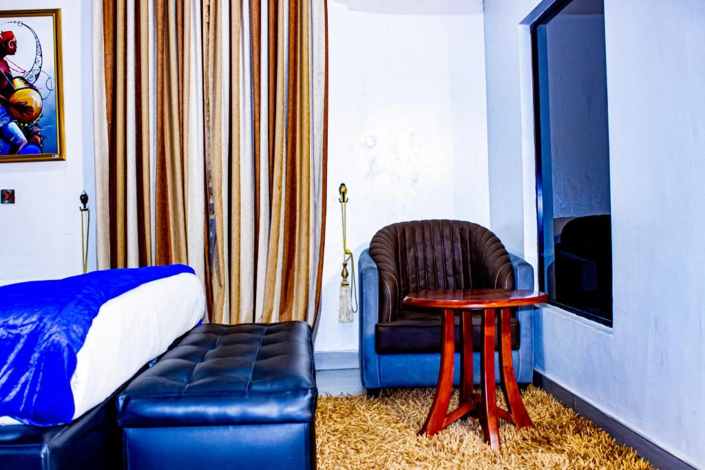 a bedroom with a couch and a chair and a table at Fobbs Apartment and Suites in Asaba