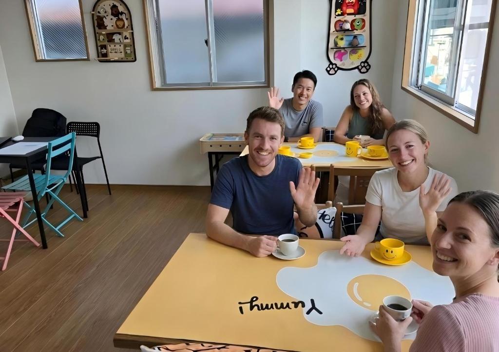 a group of people sitting at a table at Kobe Youth Hostel in Kobe