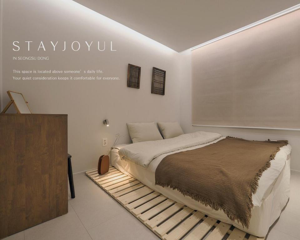 a white room with a bed and a dresser in it at Stay Seongsu Villa in Seoul
