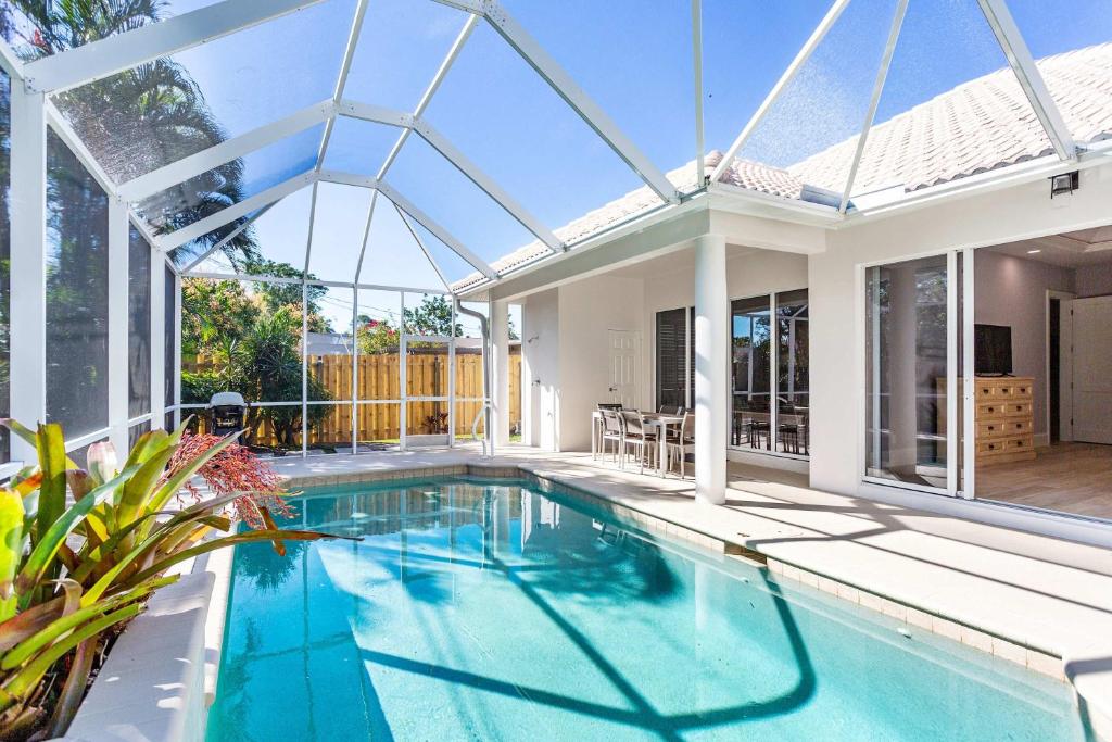 an indoor swimming pool in a house with a glass extension at Imola Vacation Rental - Remodeled Pool Home Minutes from Vanderbilt Beach! Family-Friendly Retreat with 4 BR 4 BA and Private Screened Pool! in Naples