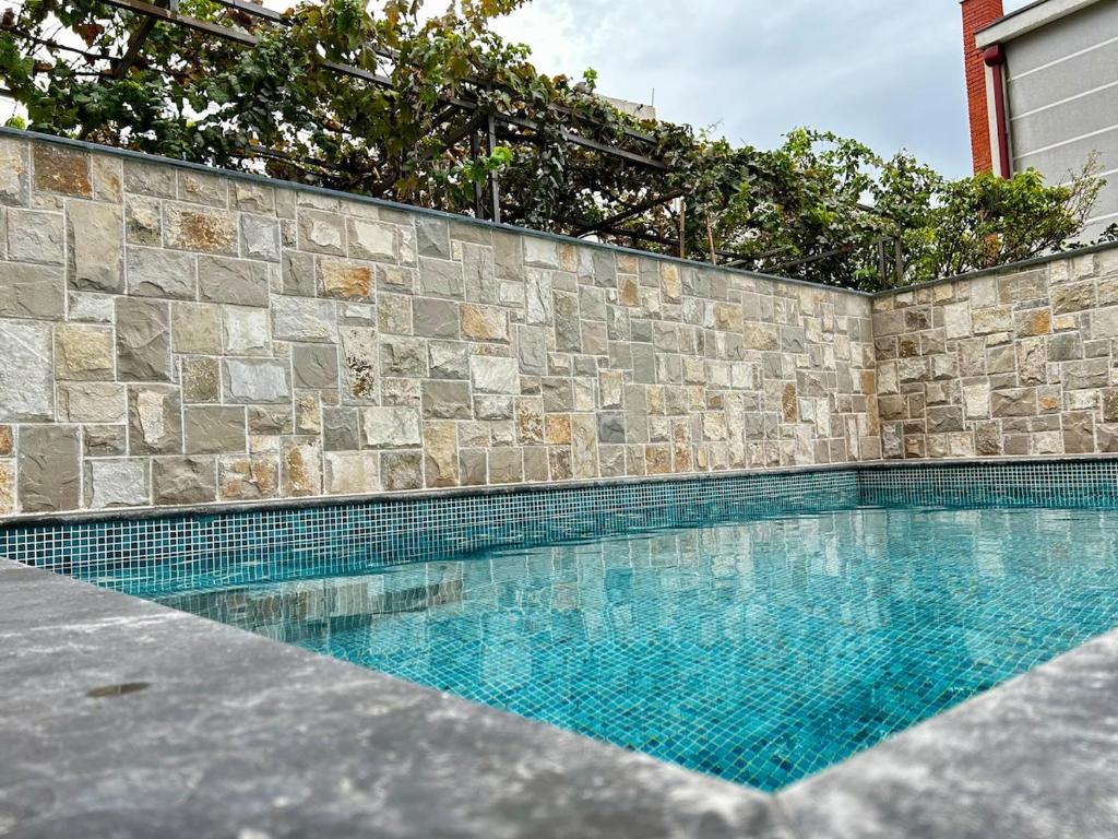 a swimming pool in front of a stone wall at Apartment Sunset - Private Pool & Sea View in Bar