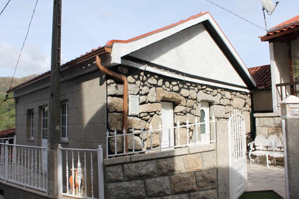 una casa de piedra con una puerta y una valla en Casa D'Aldeia, en Gerês